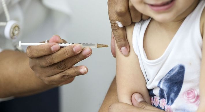A imunização da nova faixa etária já começou, e possíveis efeitos adversos geram dúvidas nos pais; especialistas alertam que risco maior é deixar de imunizar