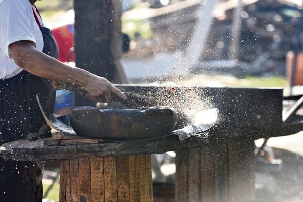 Mulheres, paneleiras de Goiabeiras, açoitando panelas com tanino extraido de mangue, durante processo de queima.