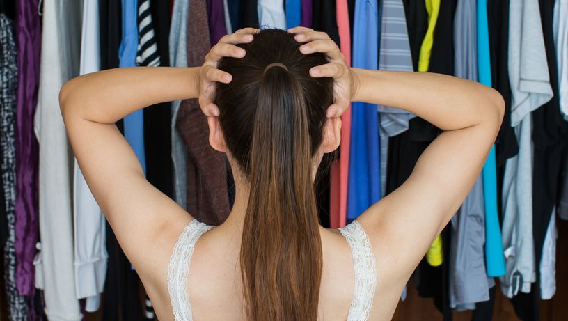 Mulher se desespera diante do guardar-roupa: organização de casa é um desafio. Tema da coluna de Lucy Mizael