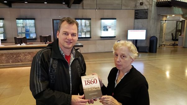 Cilmar entrega um exemplar do seu livro a Sylvie Nicolas, diretora de Atendimento ao Público do Arquivo Nacional da França. Crédito: Reprodução do Facebook