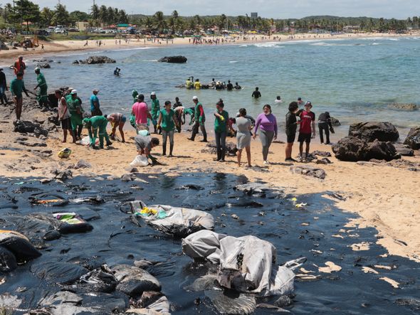 Equipes e voluntários trabalham para  conter manchas na praia Pedra de Xaréu,  no município do Cabo de Santo Agostinho, em Pernambuco por ALEXANDRE GONDIM/JC IMAGEM/ESTADÃO CONTEÚDO