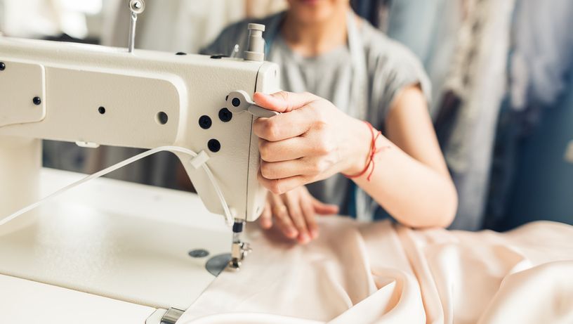Mulher costurando tecido na máquina de costura