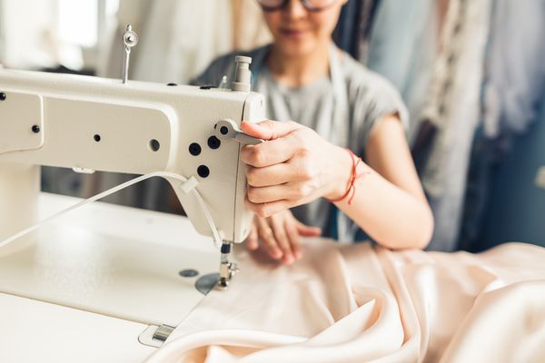 Mulher costurando tecido na máquina de costura