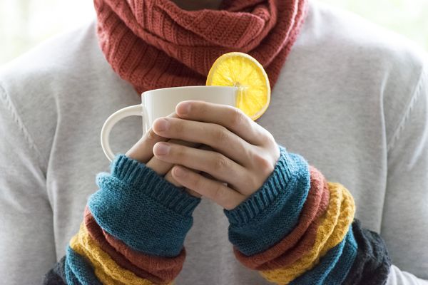 Pessoa com roupas de frio bebendo chá