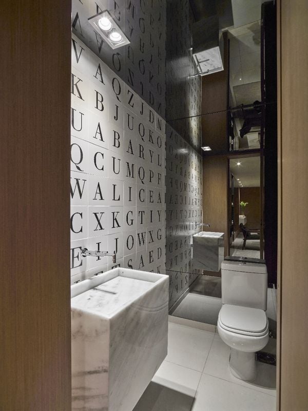 Projeto Maycon Altera. A proprietária deste lavabo é escritora, por isso o arquiteto colocou uma caça palavras em uma das paredes e no restante, incluindo teto, tudo foi revestido em espelho fume. Crédito: Jomar Bragança