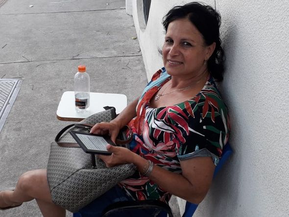 Mãe de candidato, a advogada Cláudia Bitti lê enquanto aguarda pelo filho terminar a prova do Enem por Carlos Alberto Silva