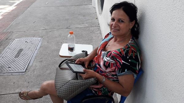 Mãe de candidato, a advogada Cláudia Bitti lê enquanto aguarda pelo filho terminar a prova do Enem. Crédito: Carlos Alberto Silva