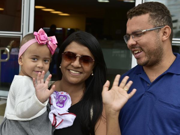 A pequena Anna Luiza recebeu alta médica nesta terça-feira (12) e acenou ao lado dos pais ao deixar o hospital. Crédito: Fernando Madeira