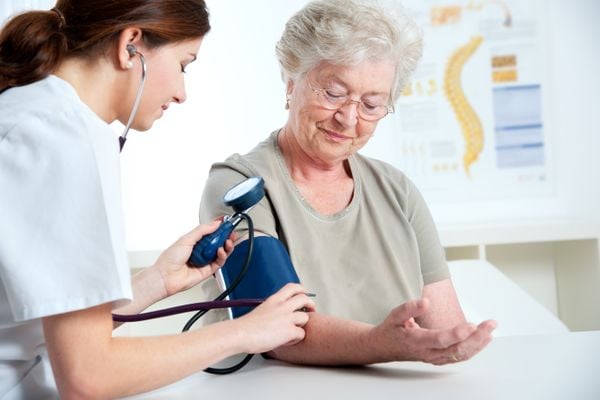 Enfermeira medindo a pressão de mulher idosa