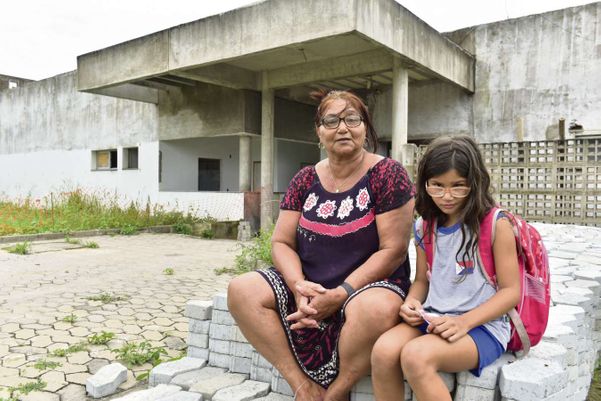 A dona de casa Maria Sueli, de 60 anos, com a neta, Julia, de 6, em frente o que deveria ser a UPA de Riviera da Barra. Crédito: Fernando Madeira