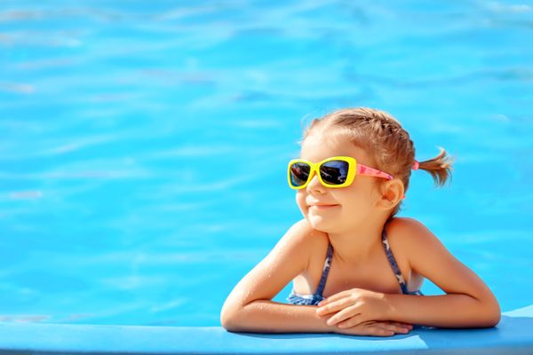 Criança de óculos de sol na piscina: todo cuidado é pouco com os pequenos no verão