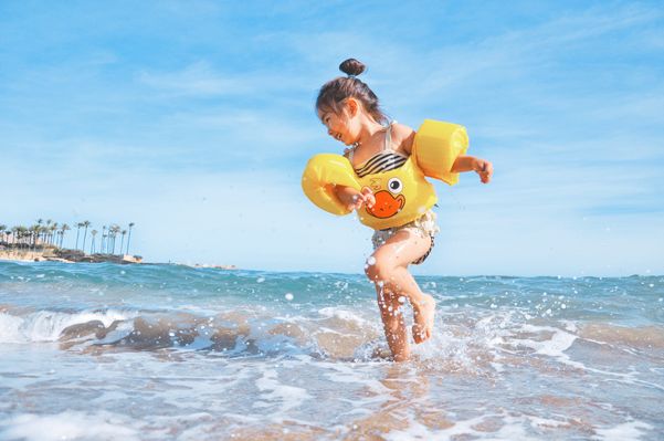 Criança se divertindo na praia: cuidados com os pequenos no verão