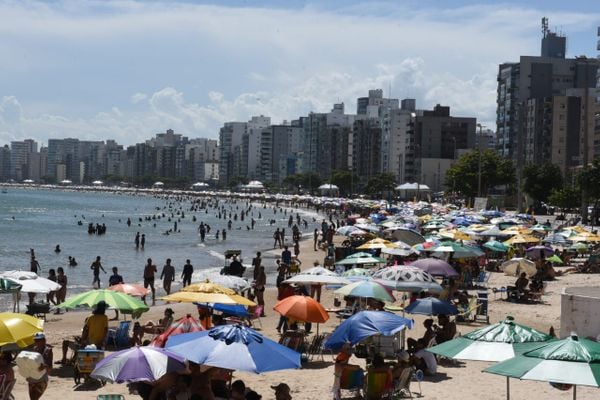 Banhistas aproveitam o dia sol na praia do Morro, em Guarapari