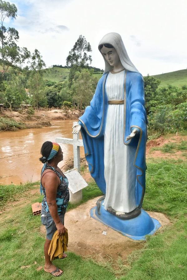 Zeladora do Centro Espírita Santo Antonio e Santa Tereza, Sebastiana Almeida de Amorim, ao lado da imagem da santa que não  foi afetada pela enchente que assolou a comunidade de Itaici, zona rural de Muniz Freire por Fernando Madeira
