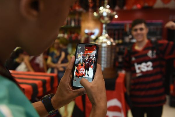Funcionário da loja do Flamengo tira foto de torcedor ao lado da taça da Libertadores  por Ricardo Medeiros