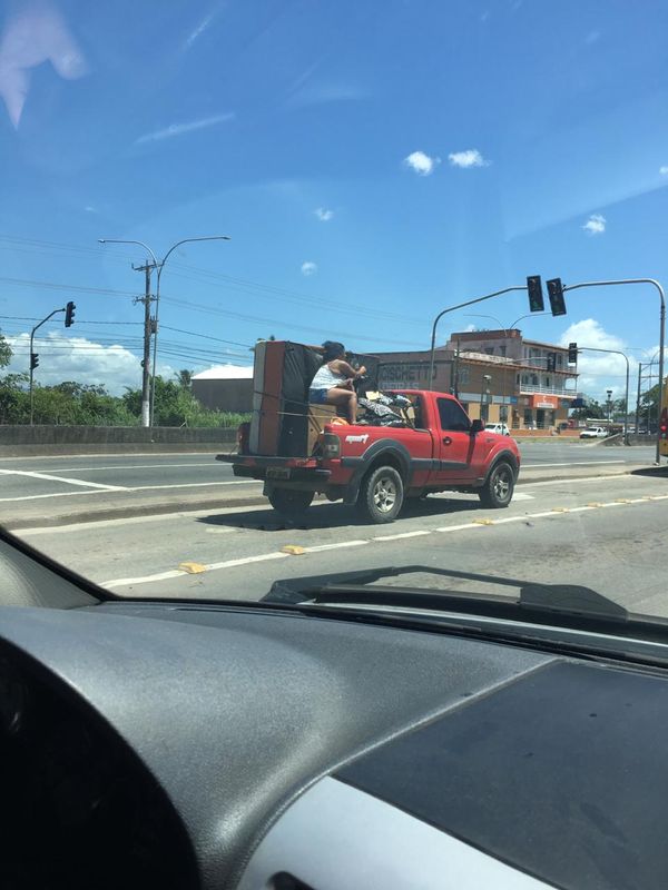 A mulher na carroceria de uma caminhonete de mudança na Rodovia do Sol. Crédito: Foto do leitor
