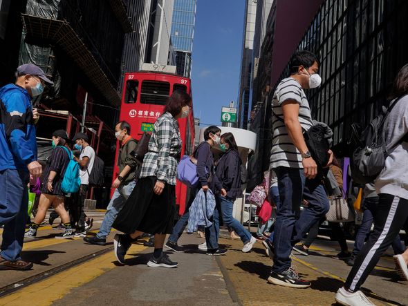 Pedestres usam máscaras de proteção nas ruas da cidade de Hong Kong, território chinês semiautônomo, nesta quarta-feira, 26. A China informou que foram registrados novos 406 casos e 52 mortes decorrentes de infecção pelo coronavírus por VINCENT YU / AP / ESTADÃO CONTEÚDO