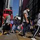 Pedestres usam máscaras de proteção nas ruas da cidade de Hong Kong, território chinês semiautônomo, nesta quarta-feira, 26. A China informou que foram registrados novos 406 casos e 52 mortes decorrentes de infecção pelo coronavírus