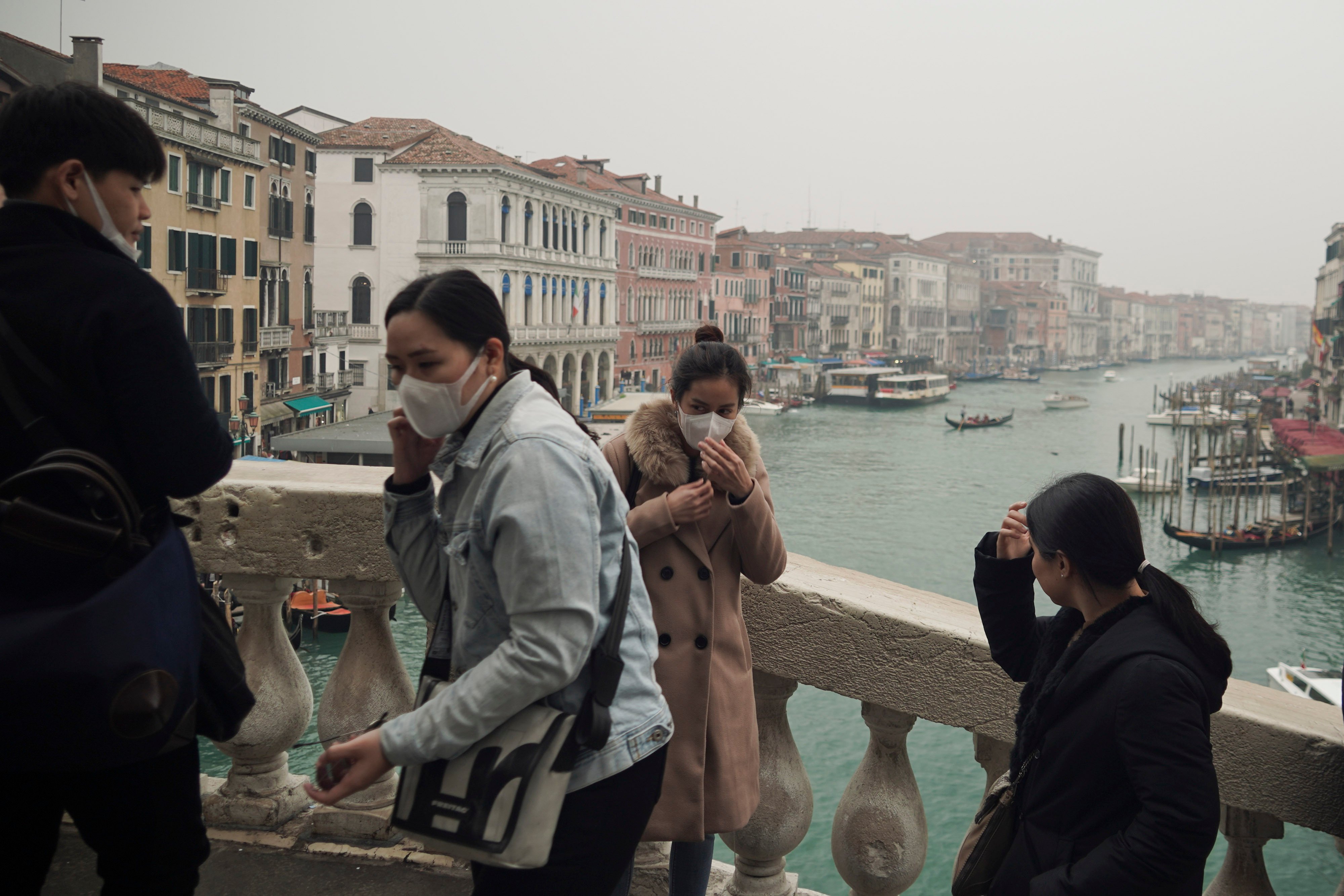 Turistas usam máscaras de proteção na cidade de Veneza, na Itália, onde o tradicional evento de carnaval foi cancelado devido ao surto do novo coronavírus