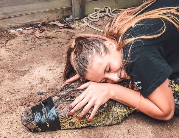 Estagiária Julie participou da captura e tirou a foto abraçadinha com o jacaré. Teria coragem?. Crédito: Divulgação | Projeto Caiman