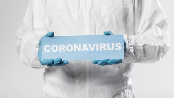  Profissional que atua em laboratório com placa do coronavírus. Crédito: Freepik