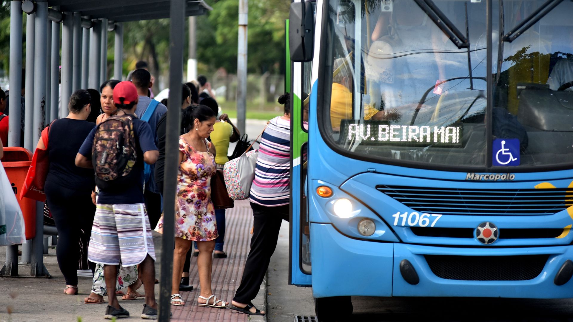 Pessoas entram em ônibus do sistema Transcol na Capital