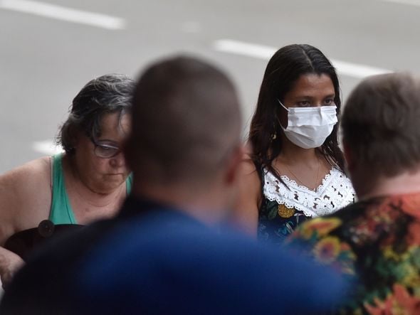 Mulher usa máscara na avenida Reta da Penha. por Vitor Jubini