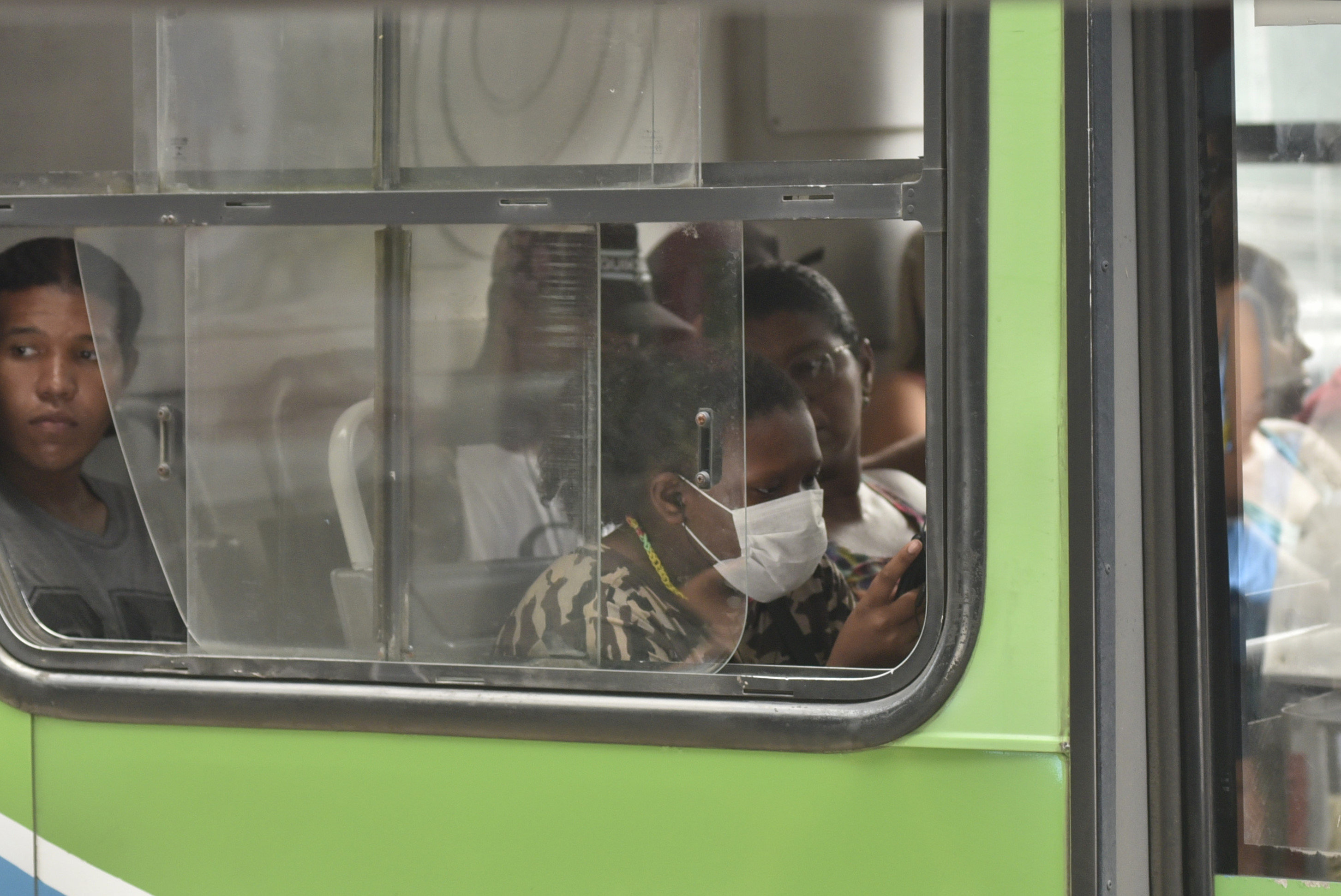 Passageira usa máscara em coletivo na Reta da Penha durante pandemia de coronavírus. 