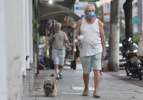 Pedestre usa máscara na Rua José Teixeira na Praia do Canto, Vitória por Vitor Jubini