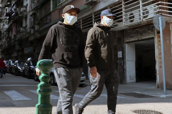 Homens usam máscara para se proteger do coronavírus na China