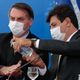 Presidente Jair Bolsonaro limpa as mãos com álcool em gel oferecido pelo ministro da saúde, Luiz Henrique Mandetta