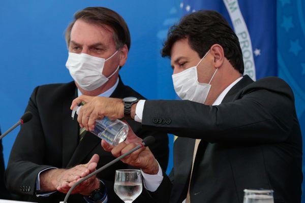 Presidente Jair Bolsonaro limpa as mãos com álcool em gel oferecido pelo ministro da saúde, Luiz Henrique Mandetta
