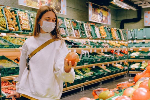 Mulher usa máscara em supermercado
