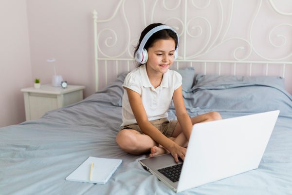 Criança estudando pelo laptop: novas adaptações na quarentena