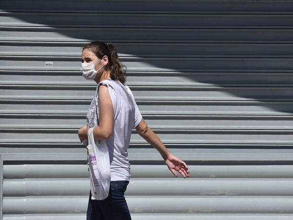Mulher usando máscara na avenida Central em Laranjeiras por Vitor Jubini