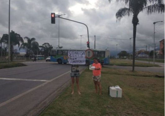 Andreia contou com a ajuda da vizinha Daiane para distribuir as marmitas na última quinta-feira (2). Crédito: Felippe Tonon Martinelli