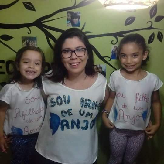 Kathyanna com a filha e a sobrinha, filha de Polyanna, no primeiro ano de entrega da água durante a Festa da Penha: camisa em homenagem à irmã que morreu às vésperas do evento