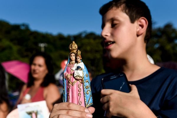 Menino com imagem de Nossa Senhora da Penha nas mãos mostra que fé não tem idade