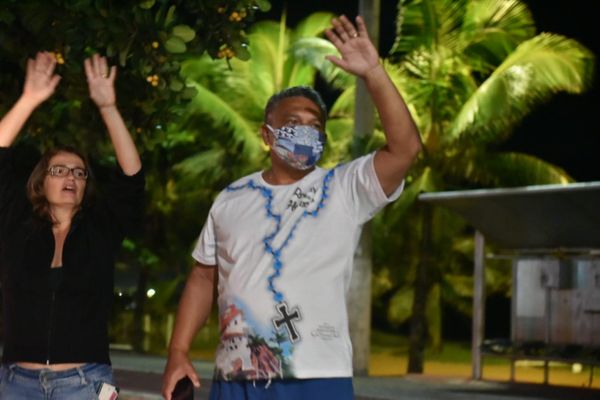 Pessoas na orla de Vila Velha interagindo com a Romaria das Famílias por Fernando Madeira