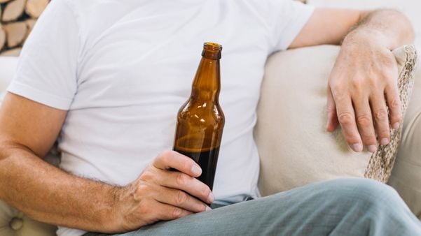 Homem bebendo cerveja em casa: aumento no consumo de bebida alcoólica na quarentena preocupa especialistas