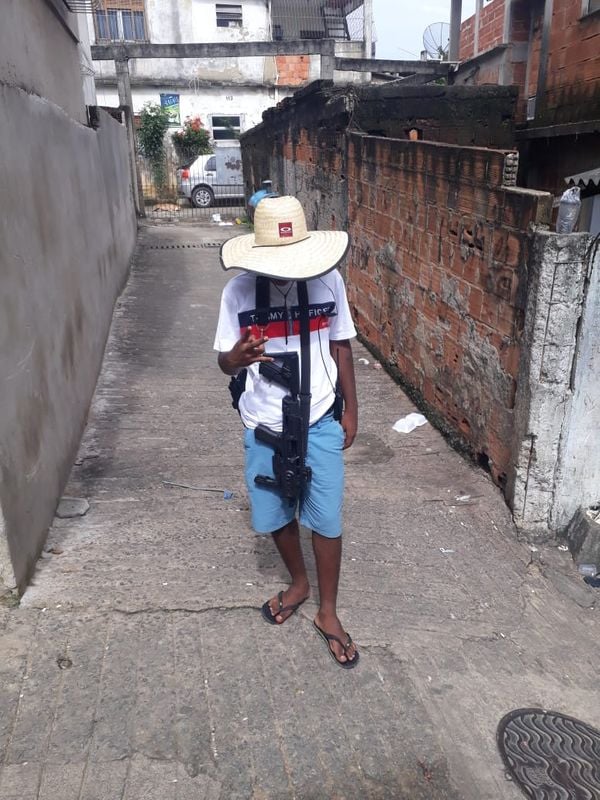 Um dos detidos que não teve o nome divulgado pela Polícia Civil aparece exibe arma longa