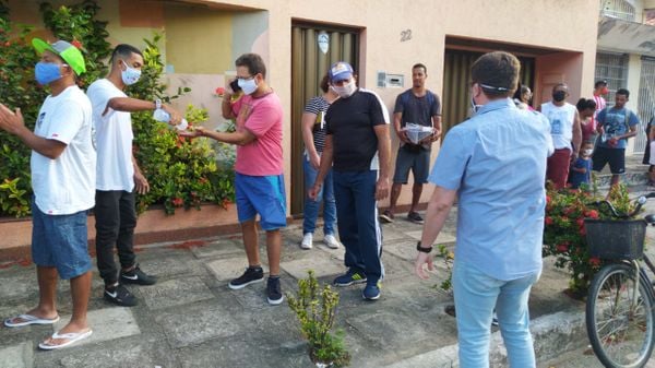 Servidores distribuem máscaras e higienizam mãos de pessoas em filas formadas nas agências da Caixa em Vila Velha