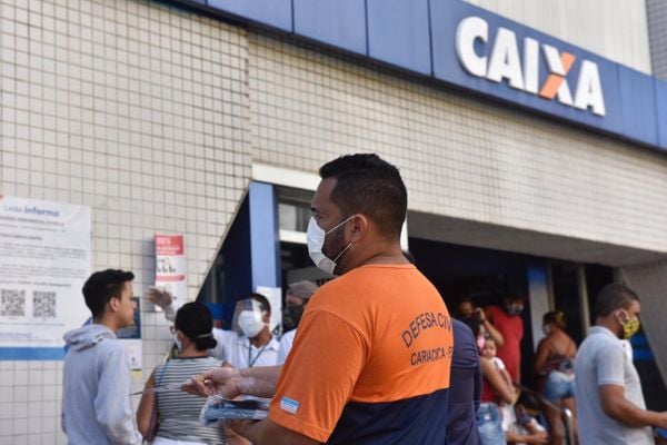 Defesa civil orientando pessoas  na fila da agência da Caixa, em Campo Grande - Cariacica/ES