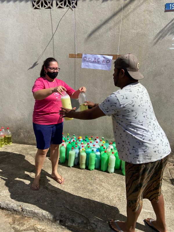 Ivanete distribui as garrafas de sabão em frente à sua casa, em Resistência