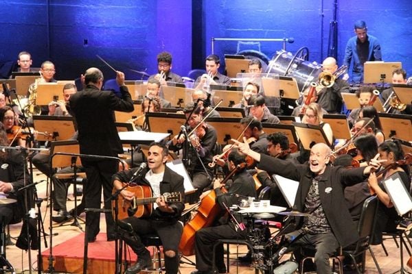 O maestro Helder Trefzger rege a Orquestra Sinfônica do Espírito Santo (Oses) com participação de Edu Henning (à frente, à direita, de frente para o palco com os braços abertos)