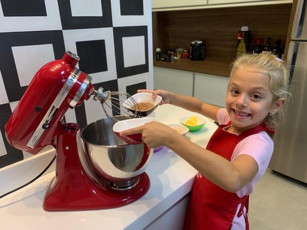 Menino brincando com um jogo de culinária dentro de casa