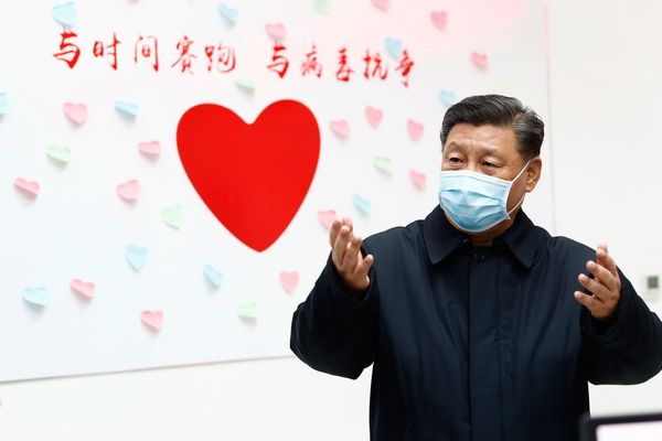 Presidente chinês, Xi Jinping, fala em frente uma placa com um coração e o slogan Corrida contra o tempo, combate ao vírus 