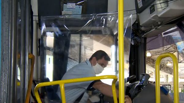 Motorista ajusta a cortina de plástico instalada para ser uma barreira física com o passageiro