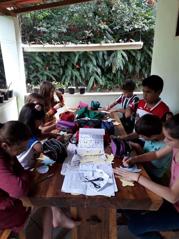 Crianças e adolescentes coordenados pela Eliane ajudando no preparativo dos materiais