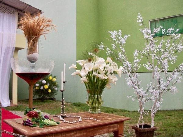 Objetos religiosos e flores montam pequenos cenários de acordo com o tema da festa 